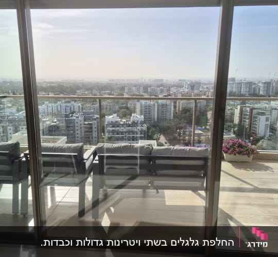 נוף עירוני מבעד לחלון זכוכית עם תריסים